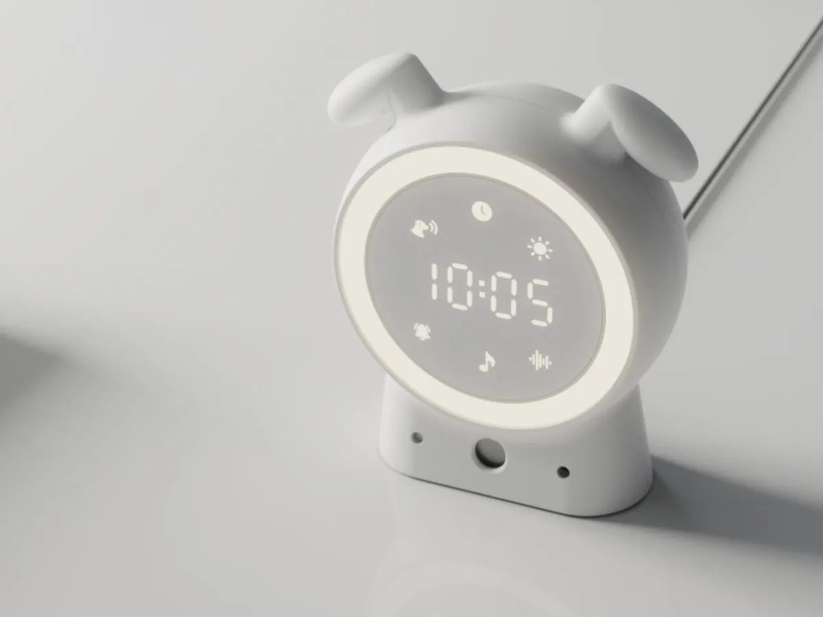 The SilentBuddy device: a rounded white bedside unit with dog-ear shapes and a light ring around its clock display
